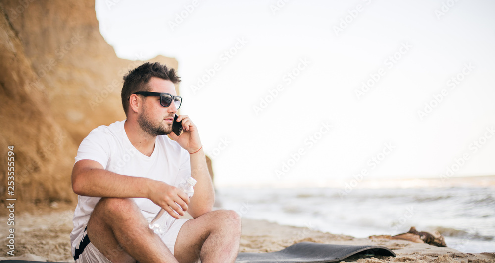 young woman talking with mobile phone on the beach