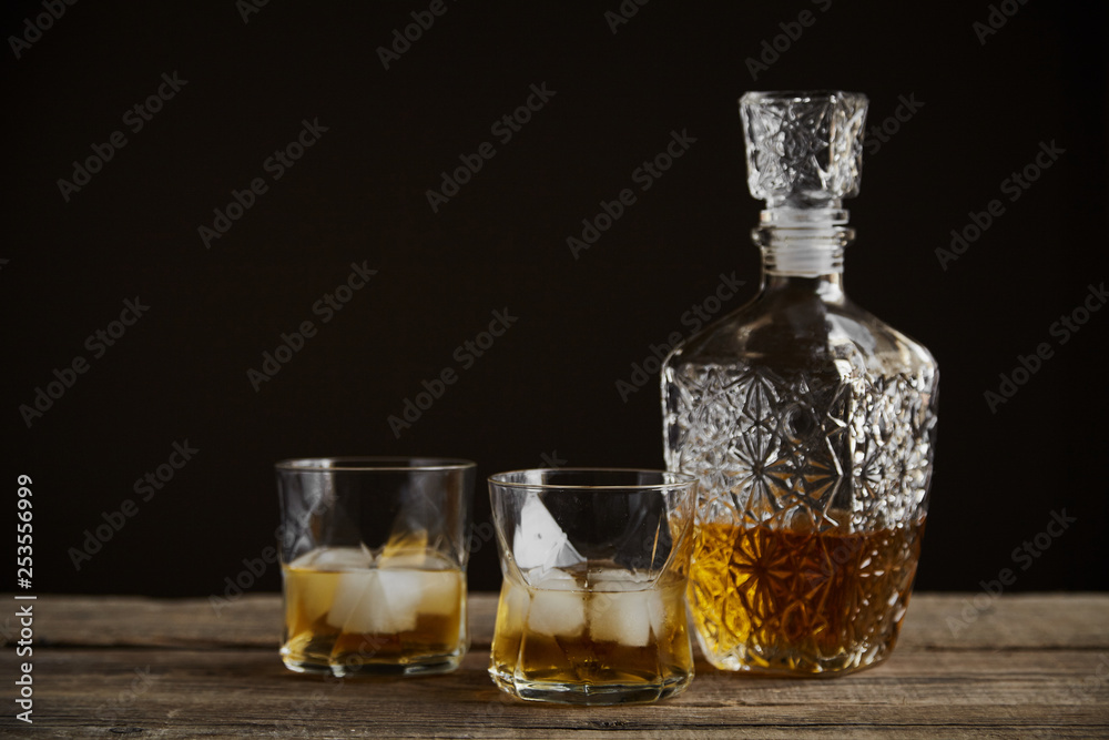 Whiskey with ice in glasses, rustic wood background, copy space Whiskey with ice in glasses, rustic wood background, copy space