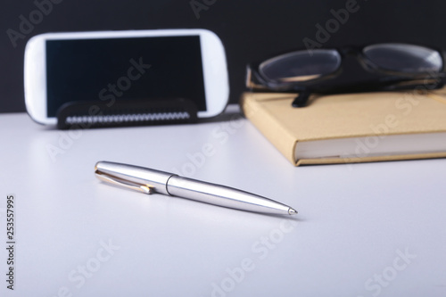 Business concept. Top view of kraft spiral notebook, glasses, smartphone and black pen isolated on background for mockup. photo