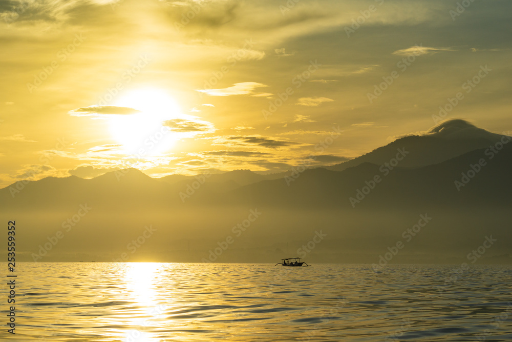 Sunrise view over tourists waiting for wild dolphin at Lovina beach in Bali, Indonesia.