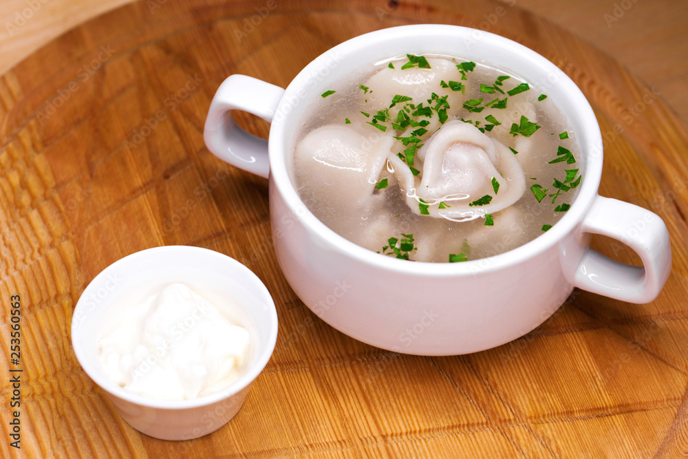 Boiled dumplings with broth in a white cup Boiled dumplings with broth in a white cup