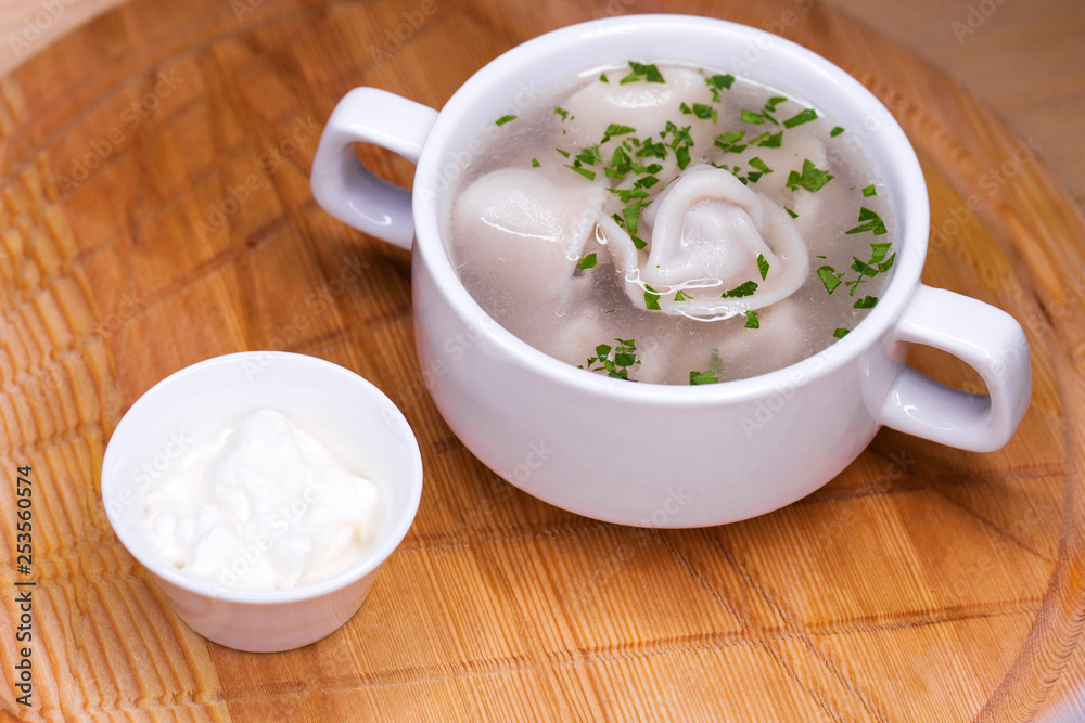 Boiled dumplings with broth in a white cup Boiled dumplings with broth in a white cup