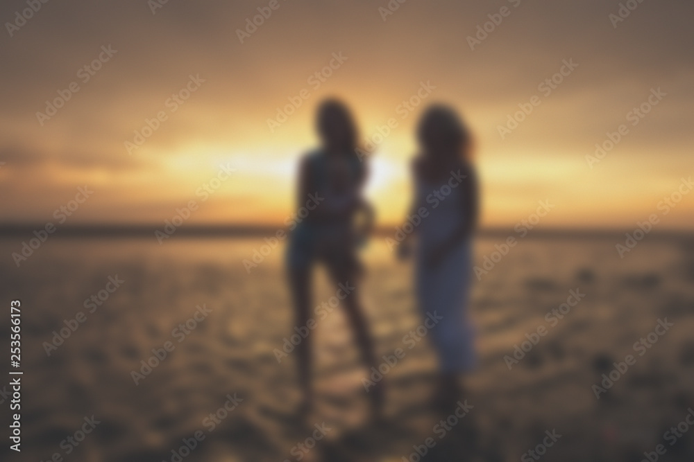 Blurred - young female homosexual lesbian family at sunset on the lake. Blurred - young female homosexual lesbian family at sunset on the lake.