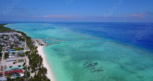 Aerial tilt shot of stunning Maldives town on island beachfront, 4k photo