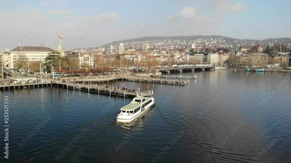 Drone shot of boat arriving at pier with passengers waiting in winter in Zurich Switzerland Drone shot of boat arriving at pier with passengers waiting in winter in Zurich Switzerland