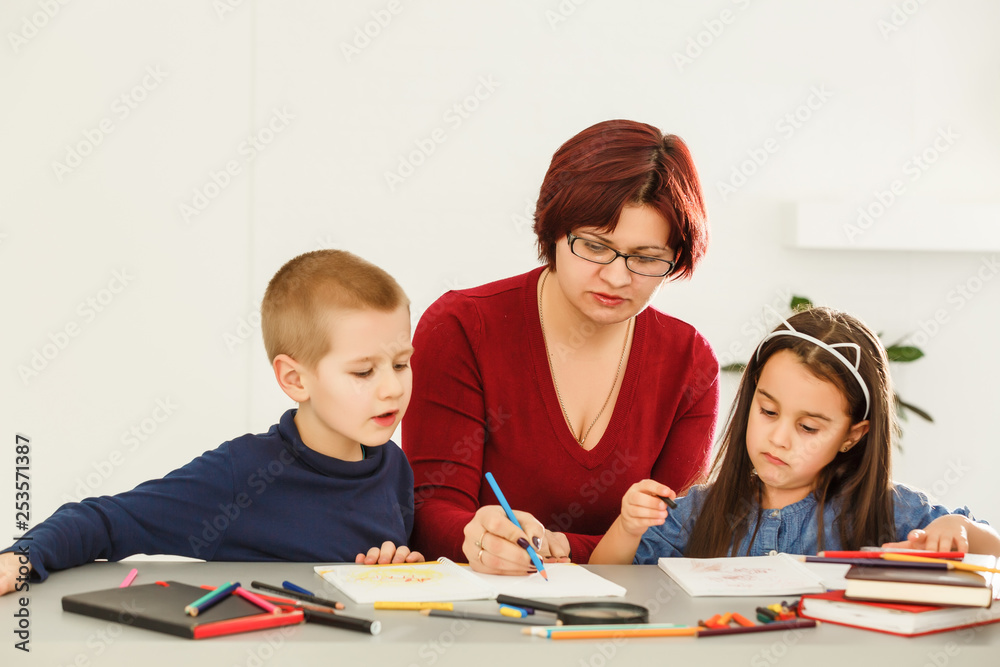 female teacher teaching mixed race kids reading book in classroom,Kindergarten pre school concept female teacher teaching mixed race kids reading book in classroom,Kindergarten pre school concept