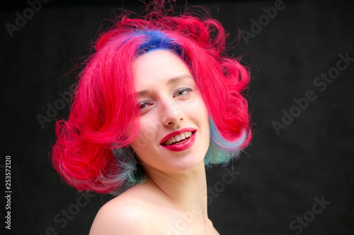 High fashion model woman with multi-colored hair posing in studio, portrait of beautiful sexy girl with a fashionable makeup and manicure.