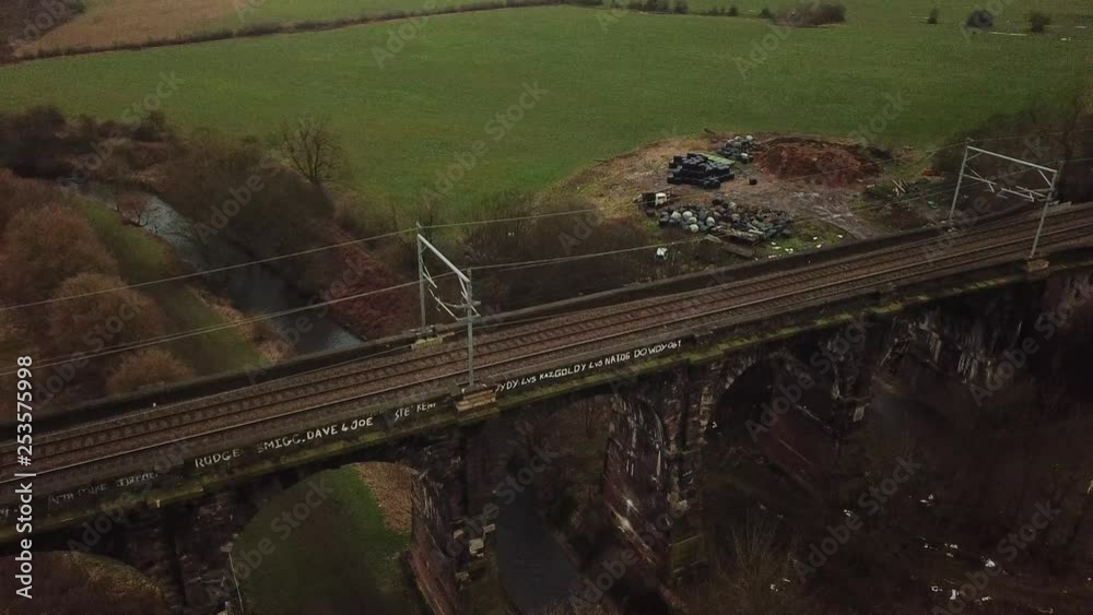 Aerial drone rotation view over stone arches on viaduct rail transport bridge in farmland countryside. Aerial drone rotation view over stone arches on viaduct rail transport bridge in farmland countryside.