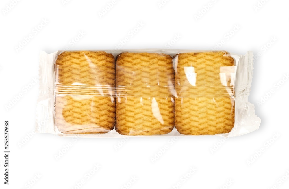 Golden cookies in a transparent package. Close up. Isolated on white background Golden cookies in a transparent package. Close up. Isolated on white background