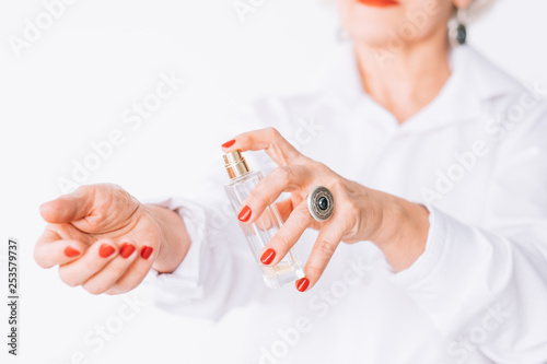 Senior female elegance. Fashion perfume trends. Stylish elderly lady applying expensive fragrance. photo