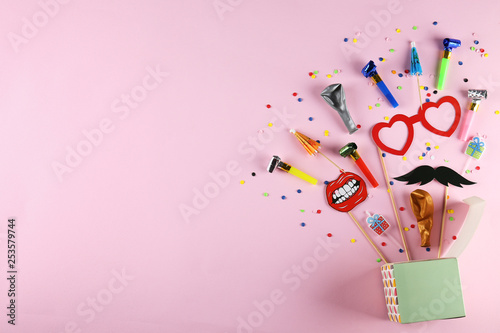 Different photo booth props on bright pink background. Paper moustache, lips and glasses on stick. Party kit for birthday, wedding or corporate event celebration. Flat lay, copy space, top view.