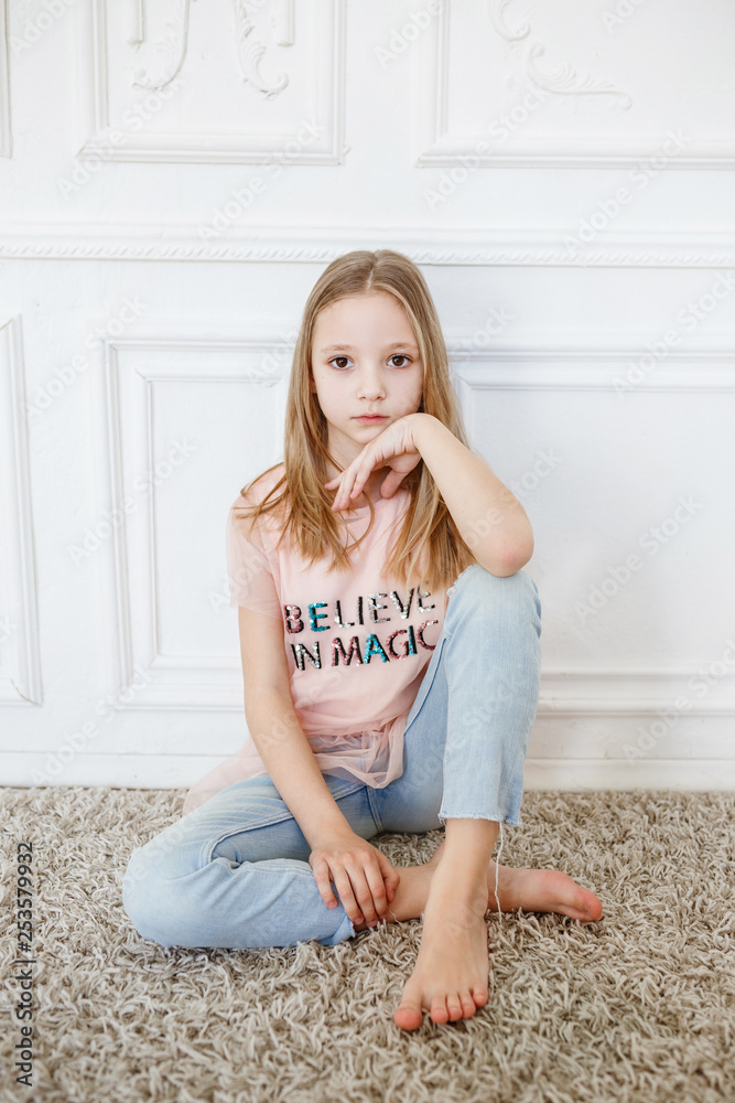 Cute pre-teen girl wearing fashion clothes posing in white interior Stock  Photo | Adobe Stock