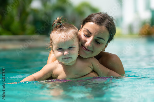 Mother and baby relaxing in a swimming pool.