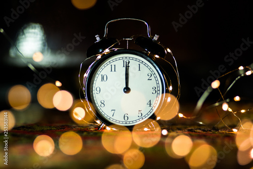 alarm clock on the eve of the holiday shrouded in garland
