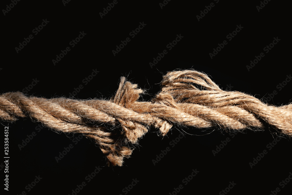 Rupture of cotton rope on black background