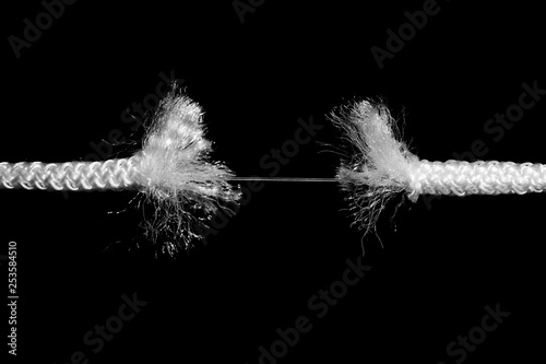 Rupture of white rope on black background photo