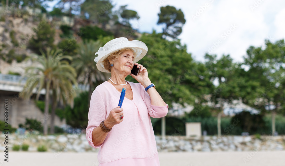 Aged woman talking on phone outdoors