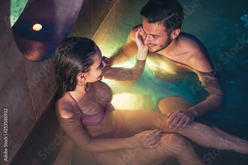 Romantic couple doing a swimming pool spa center valentine's day - Happy lovers having tender moment on vacation in resort wellness hotel - People relationship, recreation, relaxation and love concept photo