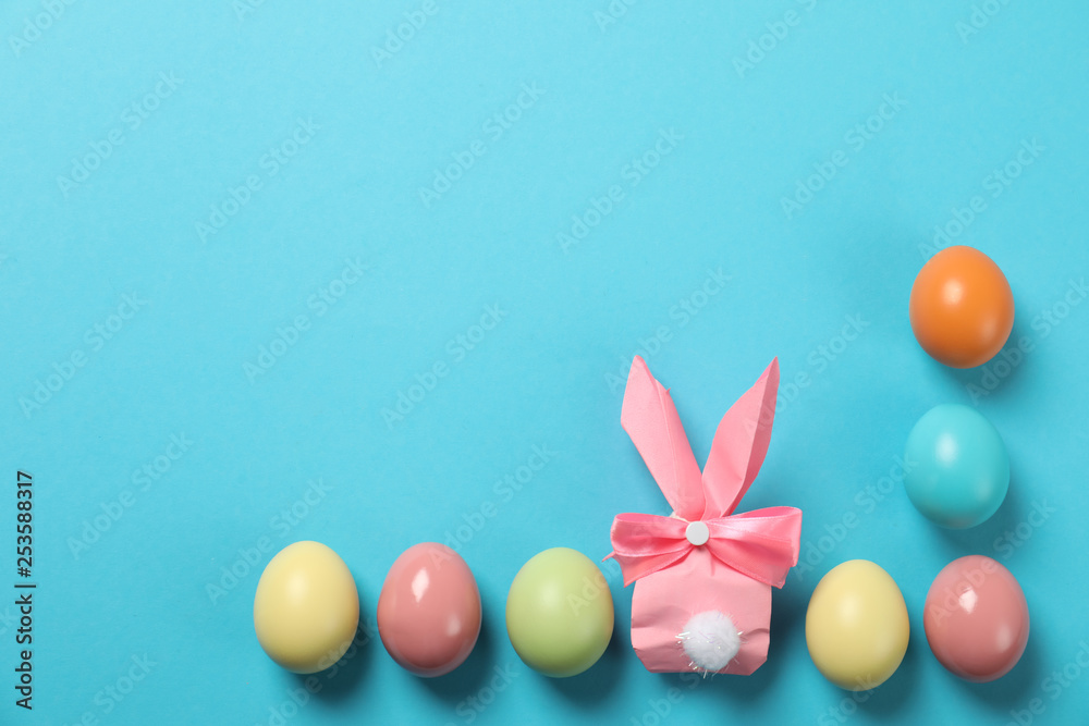 Flat lay composition of Easter bunny gift bag and dyed eggs on color background. Space for text Flat lay composition of Easter bunny gift bag and dyed eggs on color background. Space for text
