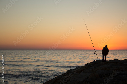 Silhouette of group of people watching the sunset on the sea