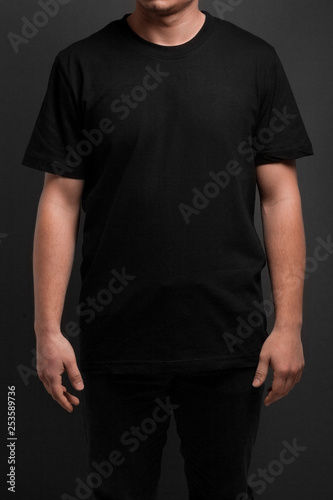  model posing in black t-shirt over gray background
