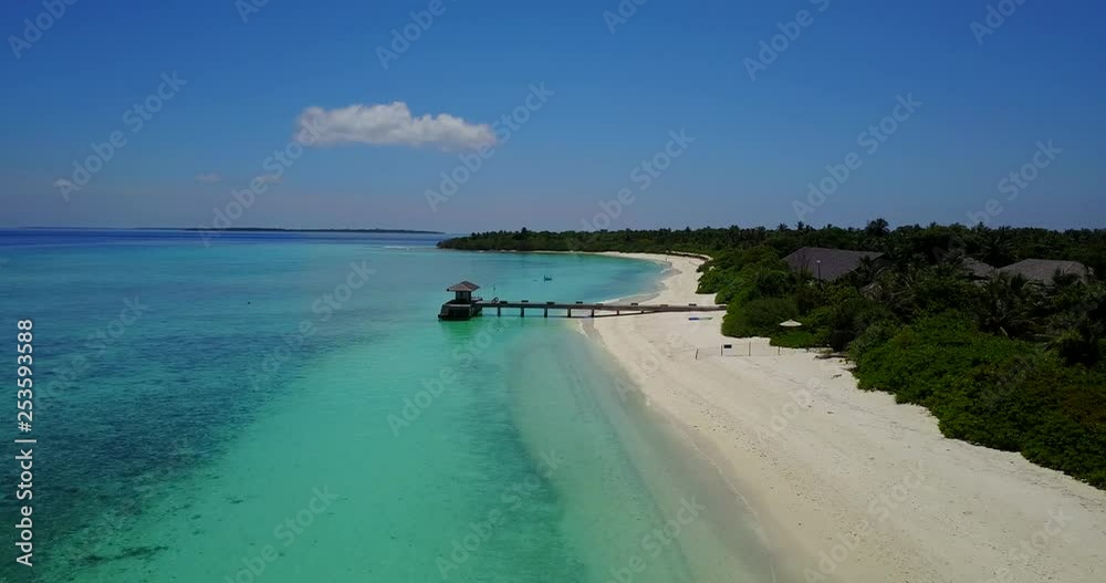 a horizontal aerial view of a resort hotel and its wood deck on the turquoise sea in the Maldives, drone footage on a clear day a horizontal aerial view of a resort hotel and its wood deck on the turquoise sea in the Maldives, drone footage on a clear day