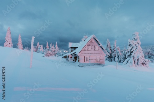 Beautiful snowy winter landscape with cottage cabin village in christmas vacation time near ski resorts. Dramatic overcast sky. Beauty world. Colorful outdoor scene celebration concept