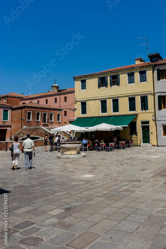 Italy, Venice, a group of people walking in front of a building