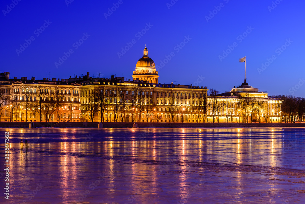 Neva river embankment panoramic landscape in Saint Petersburg. St. Isaac's Cathedral and the buildings on the waterfront in beautiful night lighting, Saint-Petersburg, Russia