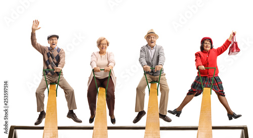 Cheerful senior people having fun on a seesaw