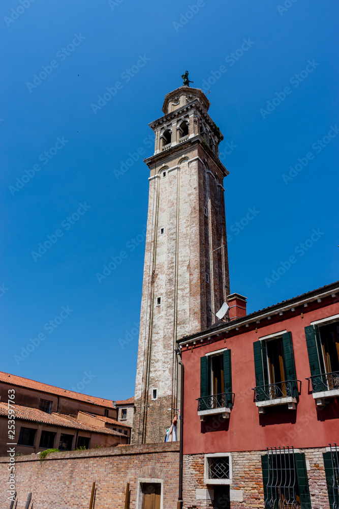 Italy, Venice, a large brick tower with a clock on the side of a building