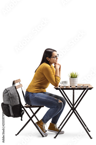 Female student in a cafe sitting at a table with coffee