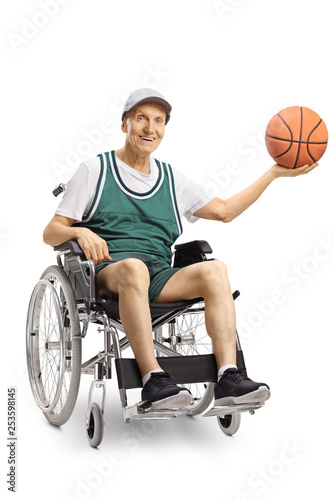 Senior disabled man in a wheelchair holding a basketball and smiling at the camera