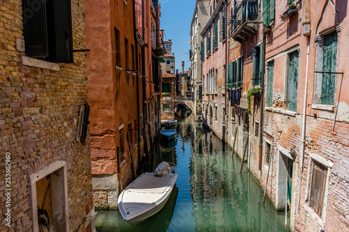 Italy, Venice, Grand Canal, BOATS MOORED IN CANAL AMIDST BUILDINGS IN CITY © SkandaRamana