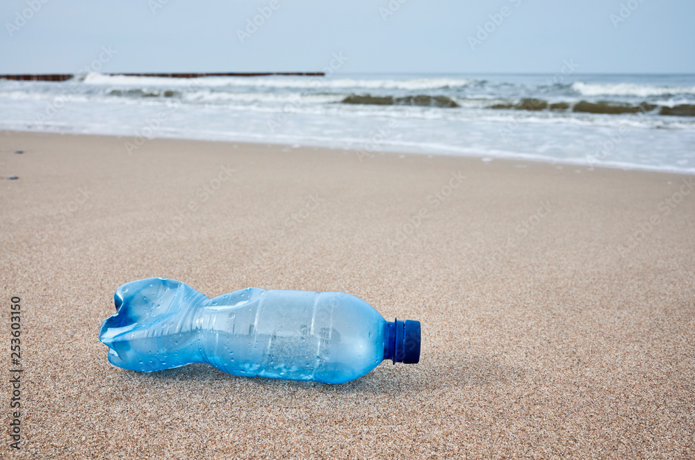 Plastic bottle left on a beach, selective focus, color toning applied. Plastic bottle left on a beach, selective focus, color toning applied.