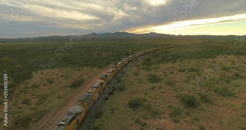 Drone flying alongside American trains in Arizona during Sunset.