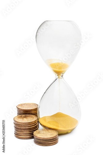 Hourglass with coins on white.