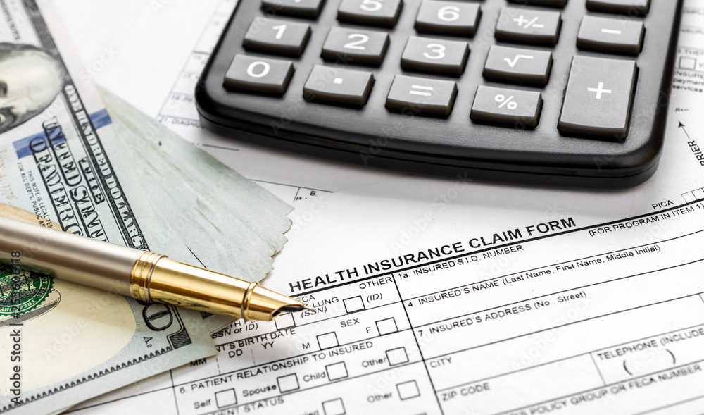 Calculator with money on health insurance claim form. Close up. Calculator with money on health insurance claim form. Close up.