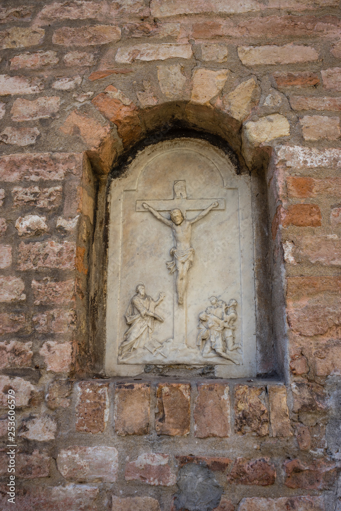 Italy, Venice, a stone building that has a christ on the side of a brick wall
