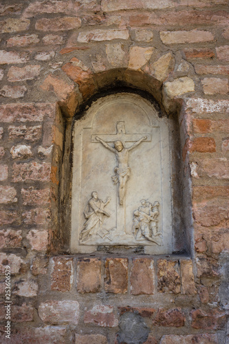 Italy, Venice, a stone building that has a christ on the side of a brick wall