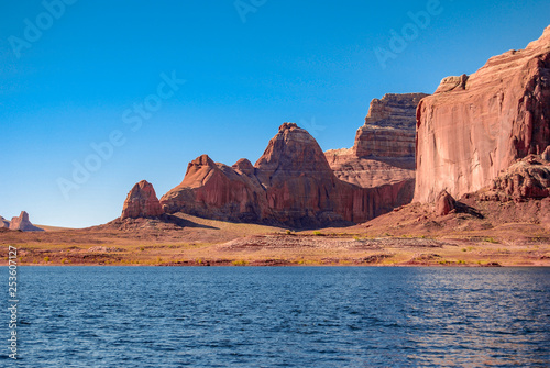 Red orange and yellow sandstone canyons and cliffs are naturally complemented by deep shades of blue. A bathtub ring is visible from the rising and then falling water levels of Lake Powell, Utah. 