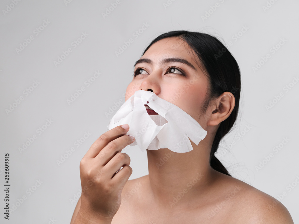 Asian woman taking off white mask from her face, lifestyle concept. Asian woman taking off white mask from her face, lifestyle concept.