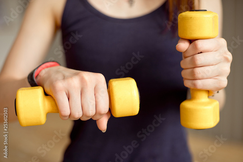 Fitness woman with barbells on grey background
