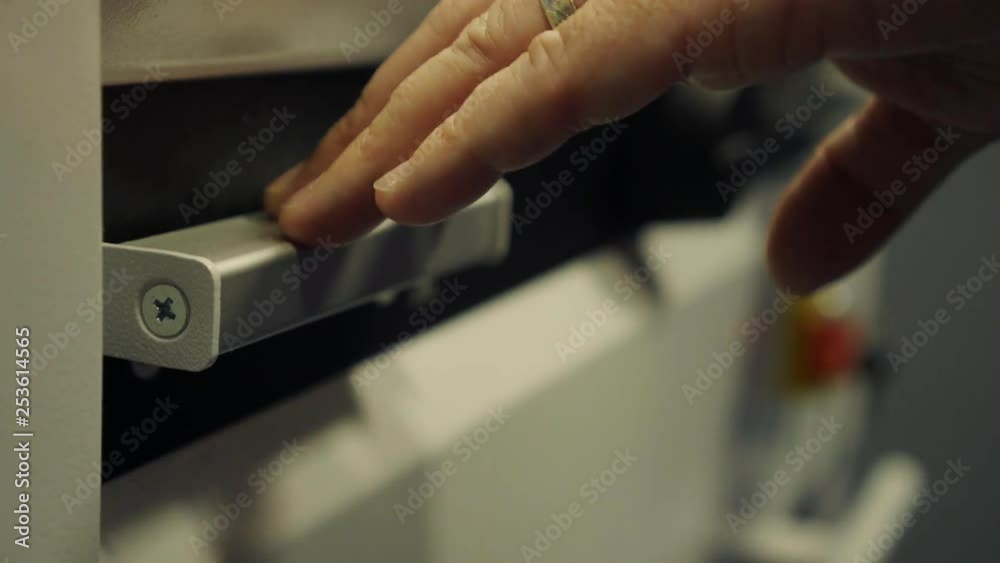 Lever on a paper cutting machine being pushed down. Lever on a paper cutting machine being pushed down.