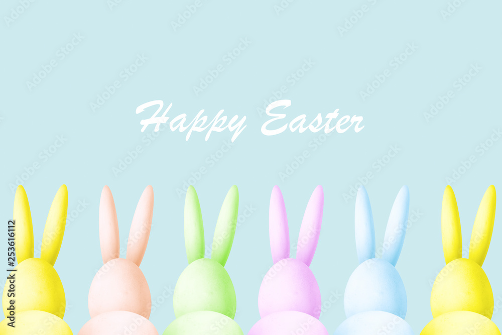 illustration of colored easter rabbits made of eggs look at the inscription happy easter, creative abstract photo on a blue background