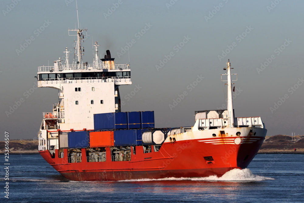 kleines rotes Feederschiff fährt in den Hafen ein kleines rotes Feederschiff fährt in den Hafen ein