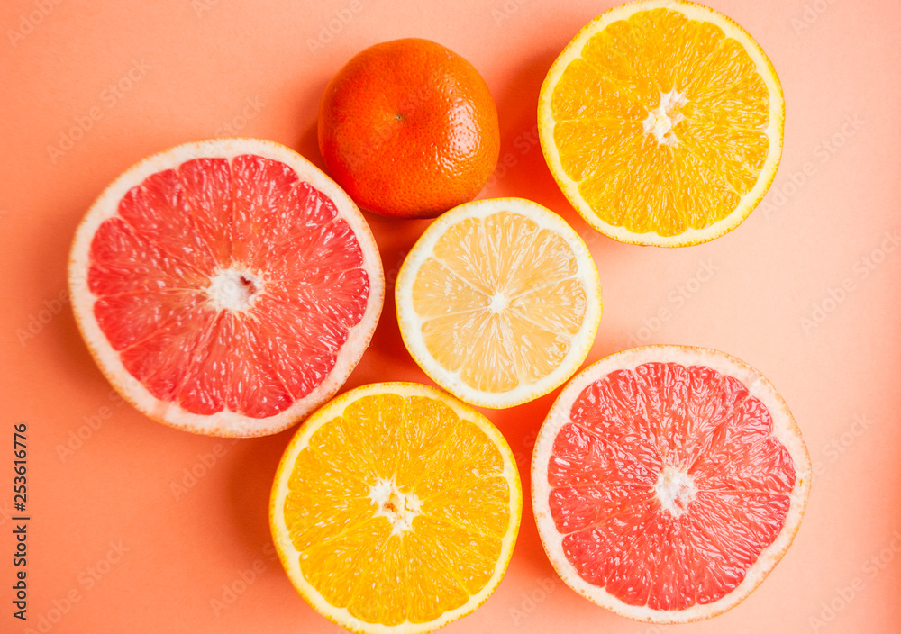 Flat lay of cut ripe juicy grapefruit, lemon and orange on orange color background. Citrus pattern. Flat lay of cut ripe juicy grapefruit, lemon and orange on orange color background. Citrus pattern.