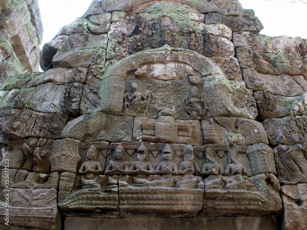 Bas-relief with stone sculptures of Buddha and Apsara dancers in Ta Prohm temple, Angkor, Cambodia