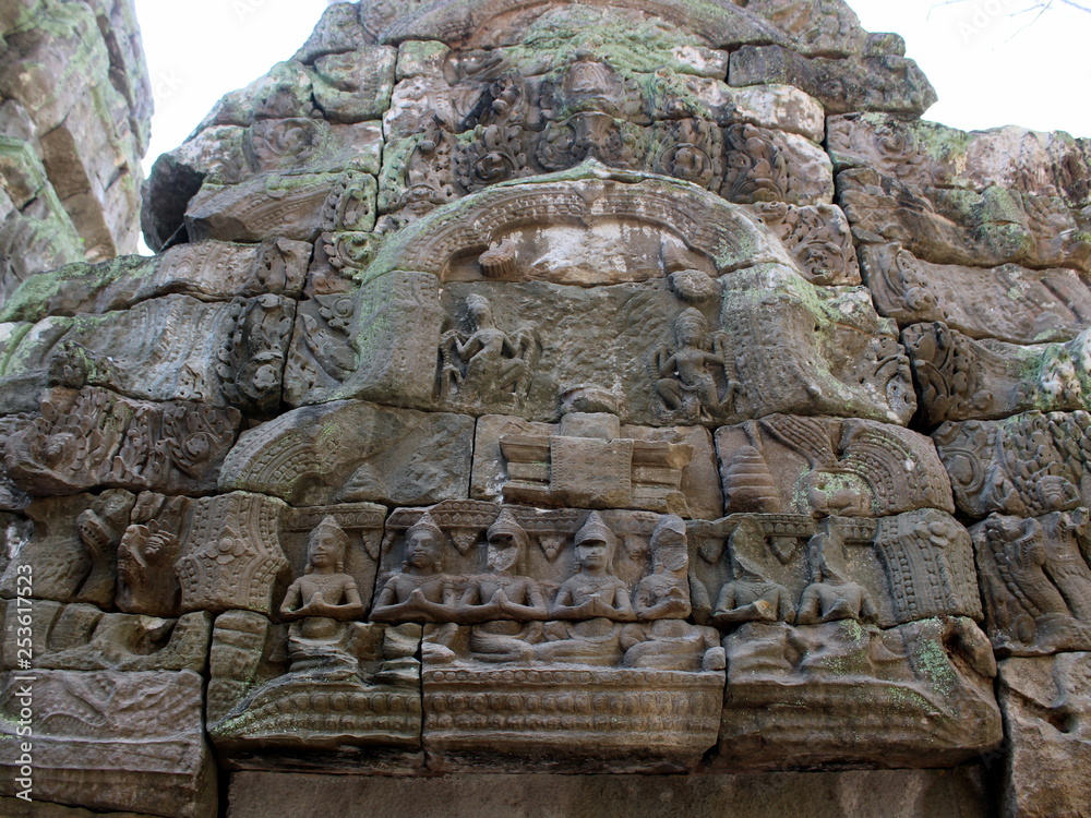 Bas-relief with stone sculptures of Buddha and Apsara dancers in Ta Prohm temple, Angkor, Cambodia Bas-relief with stone sculptures of Buddha and Apsara dancers in Ta Prohm temple, Angkor, Cambodia