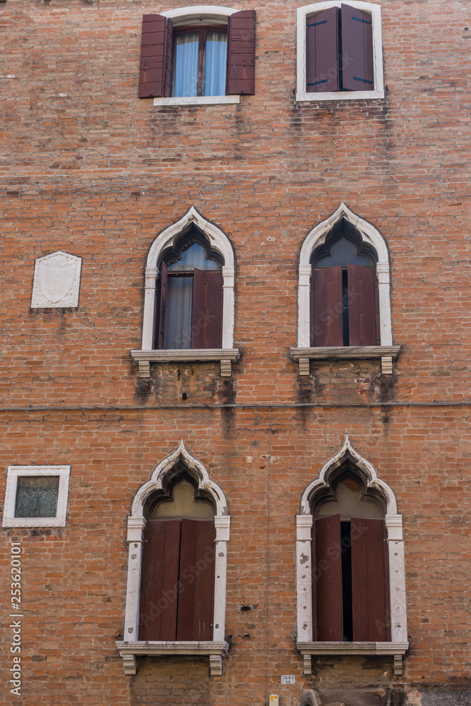 Italy, Venice, ancient windows on a red building